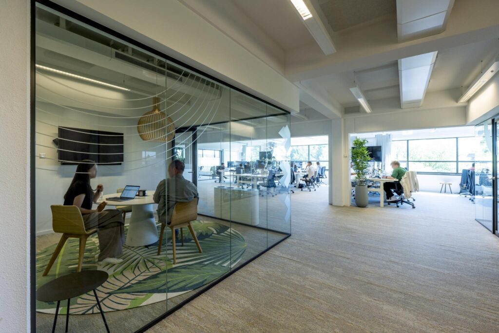 Modern office interior on Mr. Treublaan with a glass-walled meeting room and open workspace.